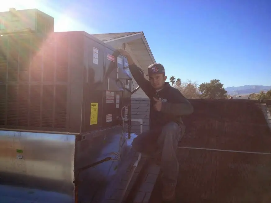 HVAC technician performing Heat Pump Repair on a rooftop unit in Woodlawn